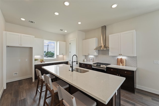 3905 Pinemont Dr Unit G, Houston, TX 77018 - kitchen with wall chimney range hood, a sink, stainless steel range with gas cooktop, white cabinetry, and tasteful backsplash