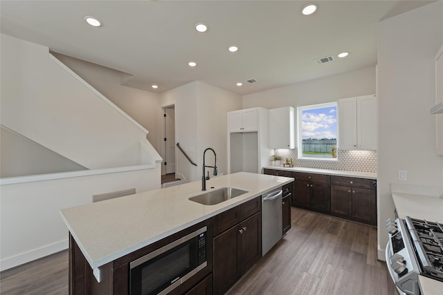 3905 Pinemont Dr Unit G, Houston, TX 77018 - kitchen with a sink, stainless steel appliances, white cabinetry, dark brown cabinetry, and light countertops