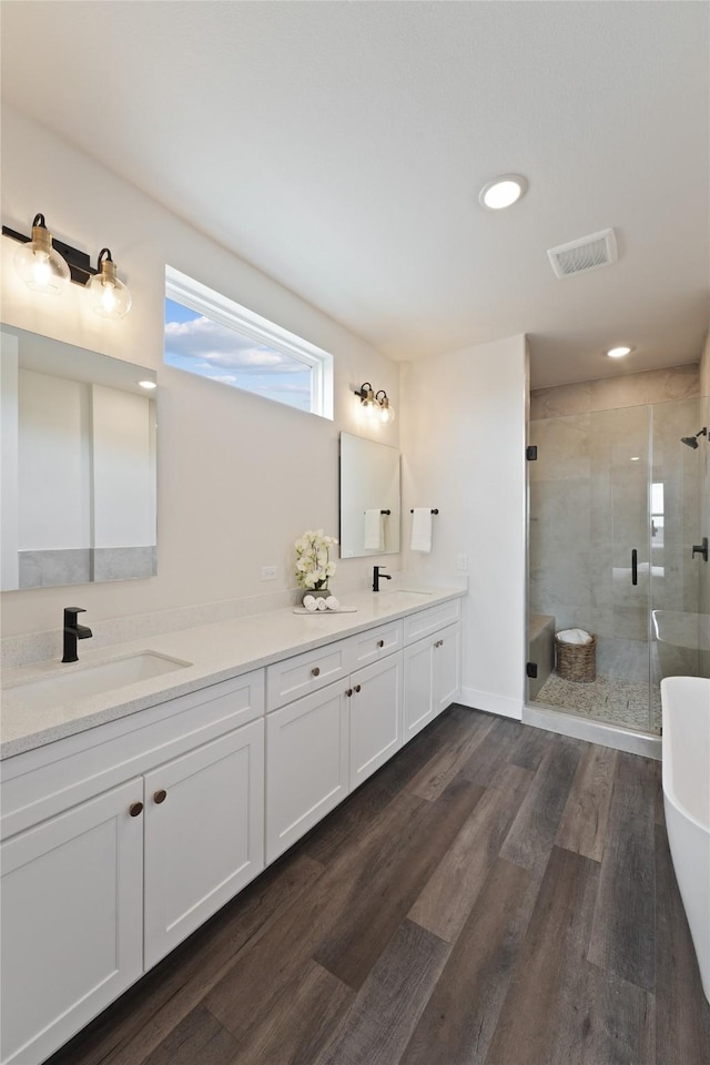 3905 Pinemont Dr Unit G, Houston, TX 77018 - full bathroom featuring a stall shower, double vanity, a freestanding bath, wood finished floors, and recessed lighting