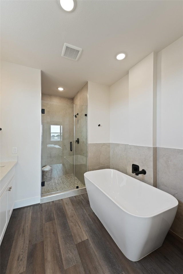 3905 Pinemont Dr Unit G, Houston, TX 77018 - full bathroom with a soaking tub, a shower stall, tile walls, vanity, and wood finished floors