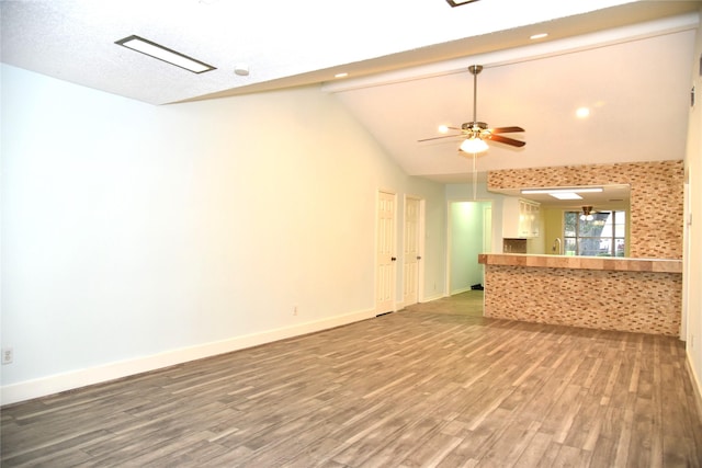 13407 Linden St, Sugar Land, TX 77498 - unfurnished living room featuring wood finished floors, vaulted ceiling, a ceiling fan, and baseboards