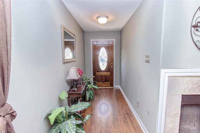 4919 Bentonite Blvd, Baytown, TX 77521 - doorway to outside featuring wood finished floors, baseboards, and a tiled fireplace