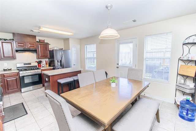 4919 Bentonite Blvd, Baytown, TX 77521 - dining space featuring light tile patterned flooring, healthy amount of natural light, and baseboards