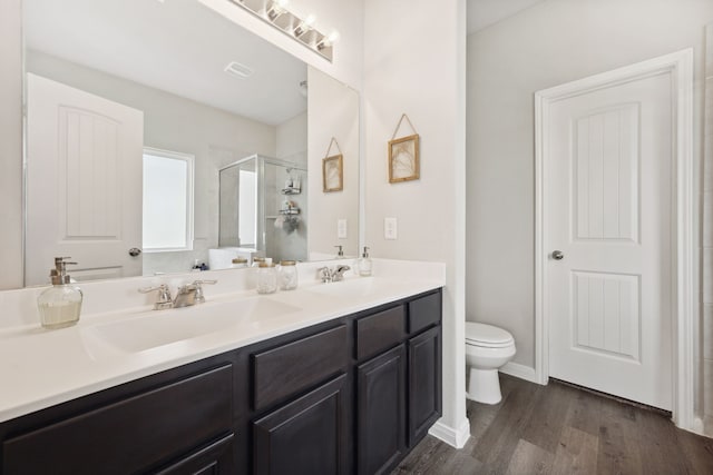 2037 Muggy Ln, Conroe, TX 77301 - full bath featuring double vanity, toilet, wood finished floors, and a stall shower