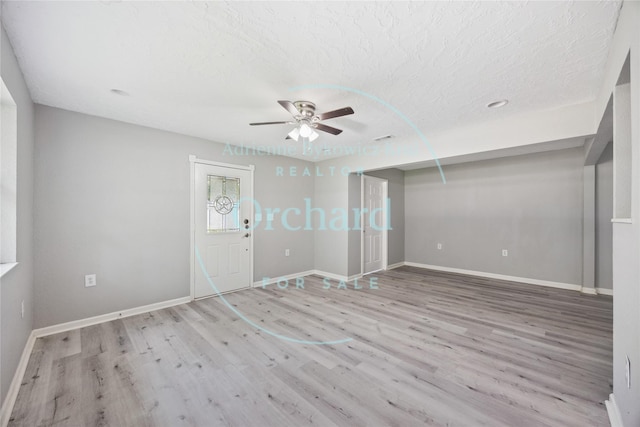 9196 White Oak Dr, Conroe, TX 77384 - unfurnished living room featuring a ceiling fan, wood finished floors, baseboards, and a textured ceiling