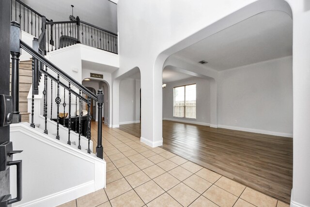 11311 Burmese Ln, Sugar Land, TX 77478 - foyer featuring arched walkways, light tile patterned floors, stairway, and baseboards