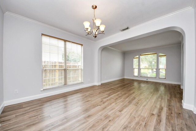 11311 Burmese Ln, Sugar Land, TX 77478 - spare room with arched walkways, a chandelier, wood finished floors, healthy amount of natural light, and crown molding