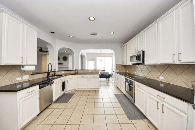 11311 Burmese Ln, Sugar Land, TX 77478 - kitchen featuring appliances with stainless steel finishes, a sink, light tile patterned floors, white cabinetry, and recessed lighting