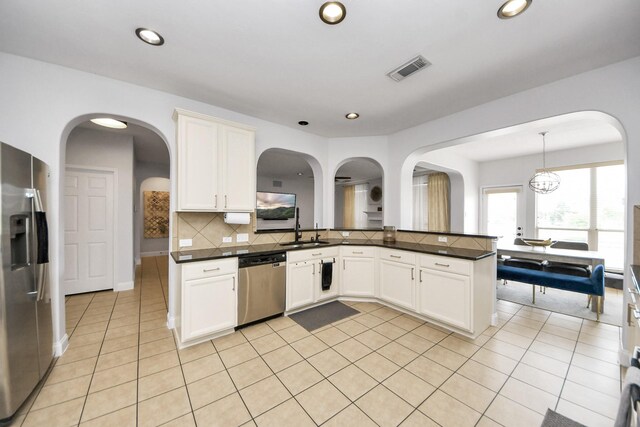 11311 Burmese Ln, Sugar Land, TX 77478 - kitchen featuring stainless steel appliances, dark countertops, a peninsula, tasteful backsplash, and light tile patterned floors