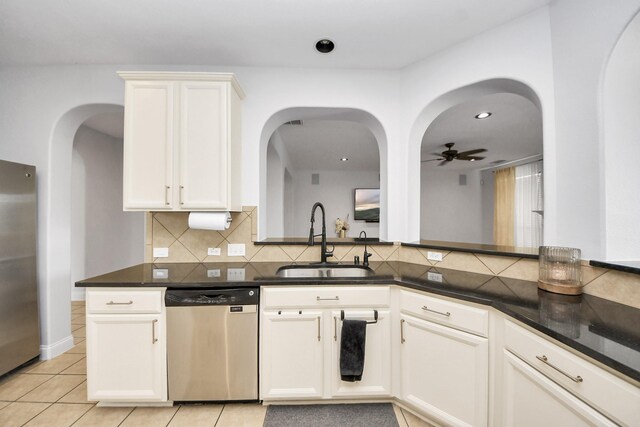 11311 Burmese Ln, Sugar Land, TX 77478 - kitchen featuring stainless steel appliances, a sink, backsplash, a ceiling fan, and arched walkways
