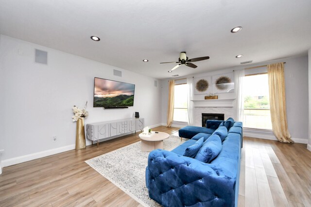 11311 Burmese Ln, Sugar Land, TX 77478 - living room with ceiling fan, plenty of natural light, recessed lighting, light wood-style floors, and a glass covered fireplace