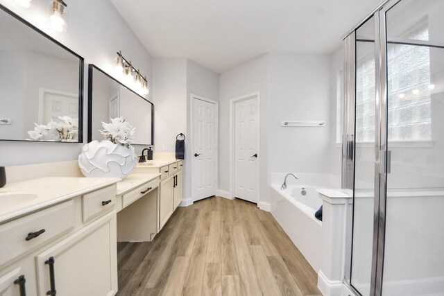 11311 Burmese Ln, Sugar Land, TX 77478 - full bath with double vanity, a garden tub, a stall shower, and wood finished floors