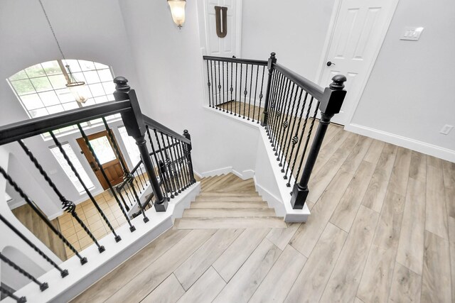 11311 Burmese Ln, Sugar Land, TX 77478 - stairway with wood finished floors, baseboards, and a towering ceiling