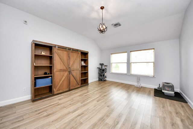 11311 Burmese Ln, Sugar Land, TX 77478 - unfurnished room featuring vaulted ceiling, light wood-style floors, a barn door, and baseboards