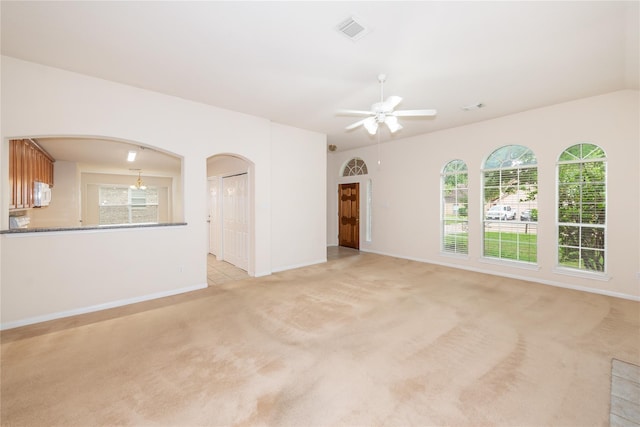 3226 Woodwind Rd, Montgomery, TX 77356 - unfurnished living room featuring light colored carpet, ceiling fan, and arched walkways