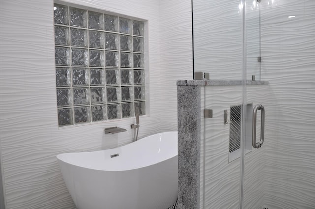 14134 Palo Seco Dr, Corpus Christi, TX 78418 - bathroom featuring a freestanding bath, a stall shower, and tile walls