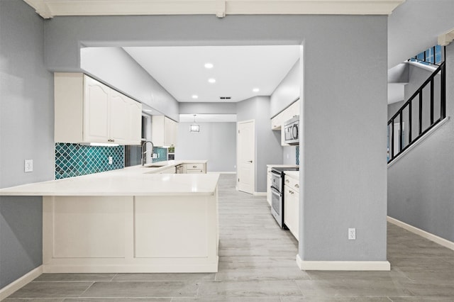14134 Palo Seco Dr, Corpus Christi, TX 78418 - kitchen featuring stainless steel appliances, a sink, a peninsula, light wood-type flooring, and recessed lighting