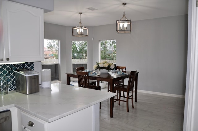 14134 Palo Seco Dr, Corpus Christi, TX 78418 - dining room with baseboards, light wood finished floors, and a chandelier