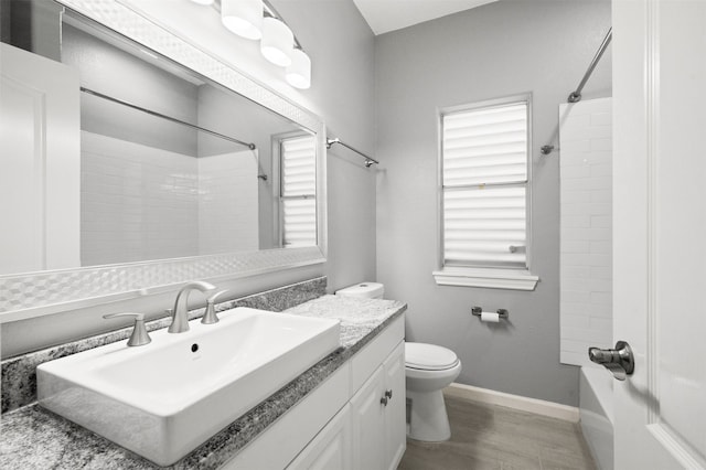 14134 Palo Seco Dr, Corpus Christi, TX 78418 - bathroom with toilet, vanity, baseboards, wood finished floors, and washtub / shower combination