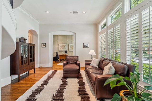 6014 Floyd St, Houston, TX 77007 - living room featuring wood finished floors, crown molding, an office area, arched walkways, and recessed lighting