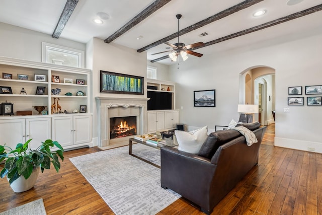6014 Floyd St, Houston, TX 77007 - living room with arched walkways, hardwood / wood-style floors, a fireplace, a ceiling fan, and beam ceiling