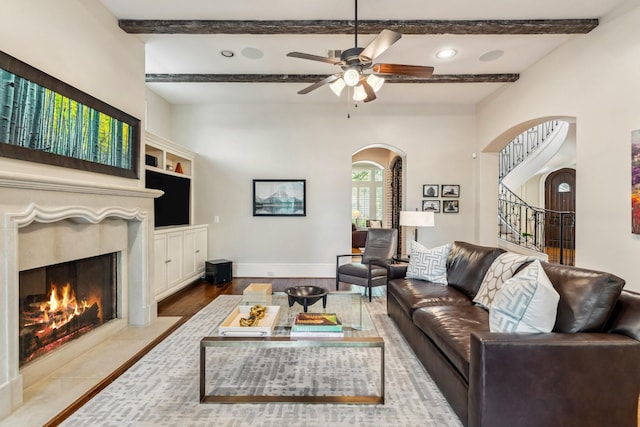6014 Floyd St, Houston, TX 77007 - living room with arched walkways, a high end fireplace, a ceiling fan, stairs, and beam ceiling