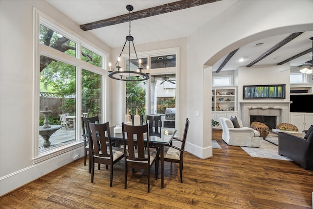 6014 Floyd St, Houston, TX 77007 - dining room with a ceiling fan, beamed ceiling, wood finished floors, arched walkways, and a fireplace