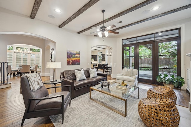6014 Floyd St, Houston, TX 77007 - living room featuring arched walkways, a chandelier, light wood-style floors, beamed ceiling, and ceiling fan