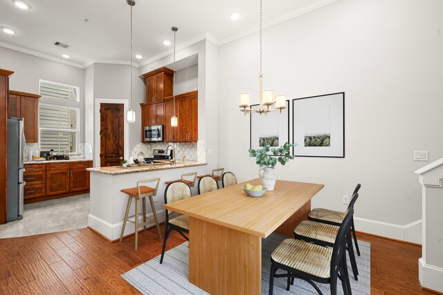 2022 Sabine St, Houston, TX 77007 - dining area with a chandelier, recessed lighting, light wood-type flooring, ornamental molding, and baseboards