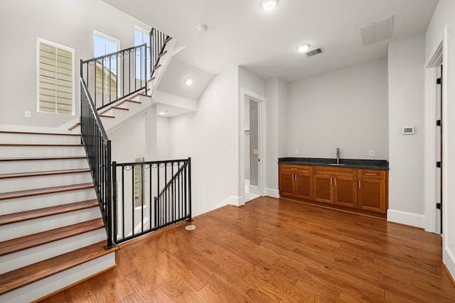 2022 Sabine St, Houston, TX 77007 - bar featuring wood finished floors, a sink, baseboards, stairs, and recessed lighting