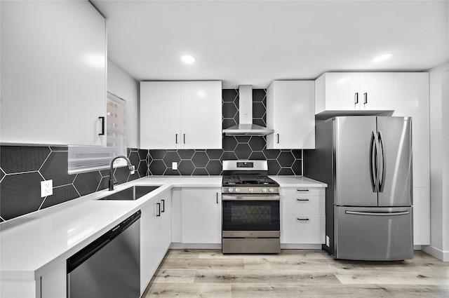 1106 W Tri Oaks Ln Unit 134, Houston, TX 77043 - kitchen featuring appliances with stainless steel finishes, wall chimney range hood, light wood-style floors, light countertops, and recessed lighting
