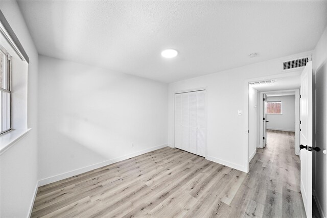 1106 W Tri Oaks Ln Unit 134, Houston, TX 77043 - unfurnished bedroom with light wood-type flooring and a closet