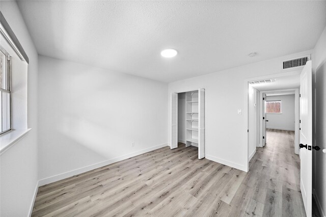 1106 W Tri Oaks Ln Unit 134, Houston, TX 77043 - unfurnished bedroom with light wood-type flooring and a closet