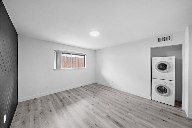 1106 W Tri Oaks Ln Unit 134, Houston, TX 77043 - laundry area featuring stacked washer and clothes dryer and wood finished floors