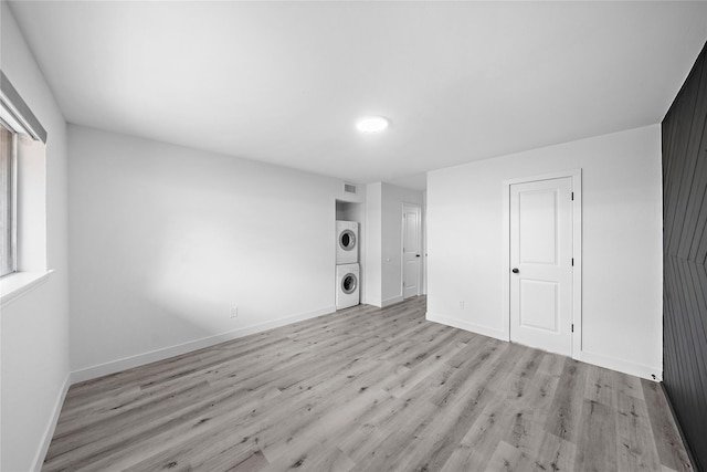 1106 W Tri Oaks Ln Unit 134, Houston, TX 77043 - unfurnished living room with estacked washer and dryer and light wood-style floors