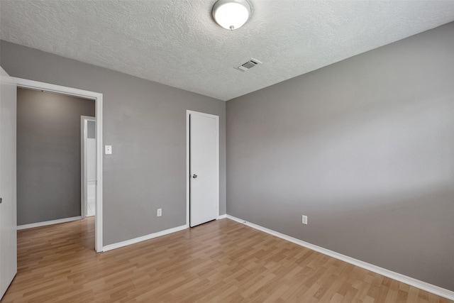 20110 Misty Pines Dr, Humble, TX 77346 - unfurnished bedroom featuring light wood-style flooring, baseboards, and a textured ceiling