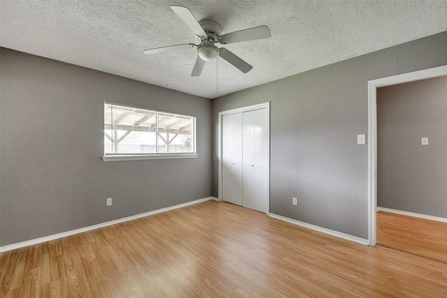 20110 Misty Pines Dr, Humble, TX 77346 - unfurnished bedroom with wood finished floors, a closet, a textured ceiling, baseboards, and ceiling fan