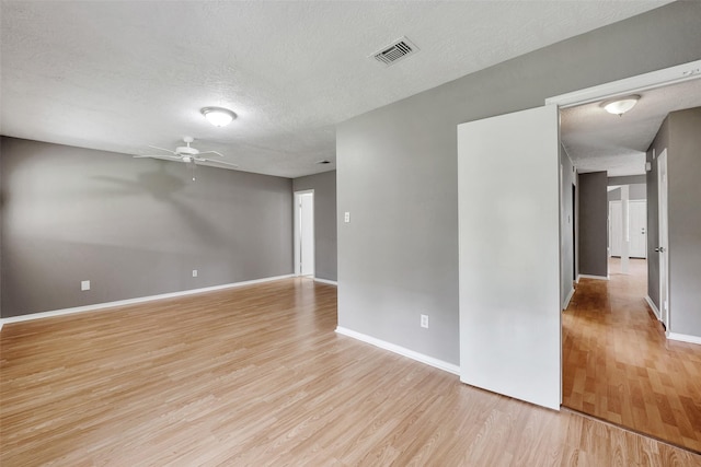 20110 Misty Pines Dr, Humble, TX 77346 - empty room with light wood-style floors, a textured ceiling, a ceiling fan, and baseboards
