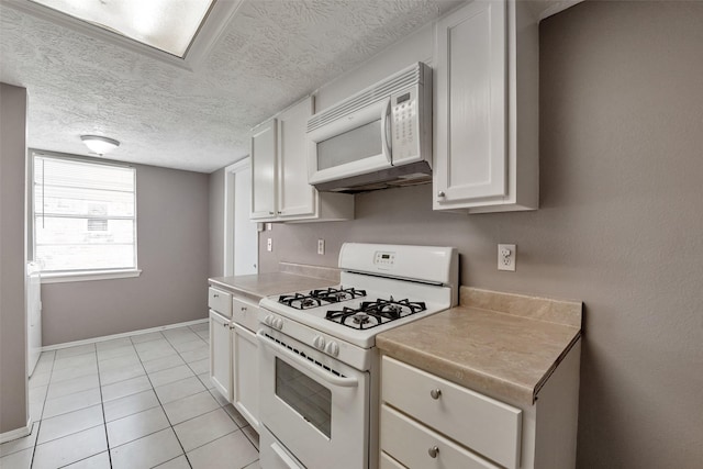 20110 Misty Pines Dr, Humble, TX 77346 - kitchen with white appliances, white cabinets, light countertops, baseboards, and light tile patterned floors