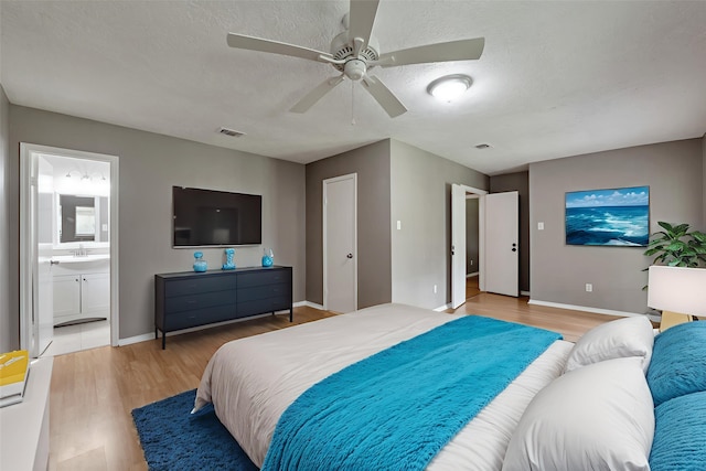 20110 Misty Pines Dr, Humble, TX 77346 - bedroom featuring light wood-style flooring, a sink, baseboards, ensuite bath, and ceiling fan