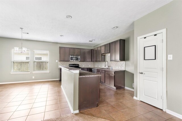6015 Coleus St, Crosby, TX 77532 - kitchen featuring appliances with stainless steel finishes, dark brown cabinets, light tile patterned flooring, a chandelier, and decorative backsplash