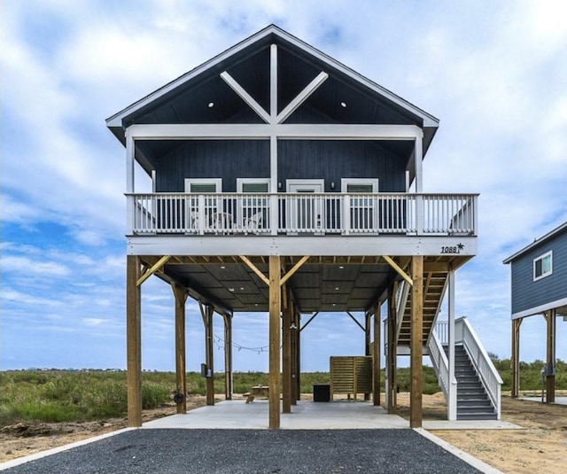 1088 Johnson Rd, Gilchrist, TX 77617 - view of front facade with stairs, a deck, a carport, and gravel driveway