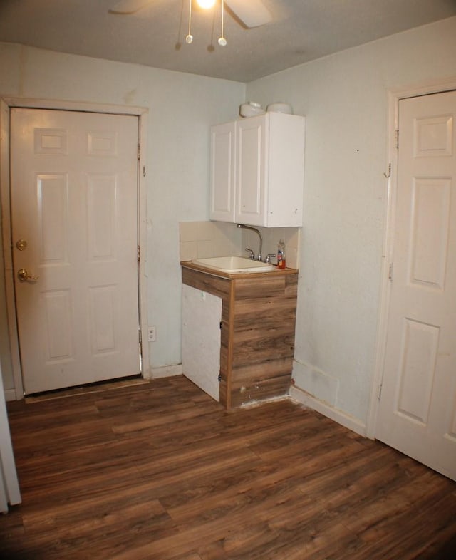 1611 Chapman St, Houston, TX 77009 - kitchen featuring a sink, white cabinetry, dark wood-style flooring, a ceiling fan, and baseboards