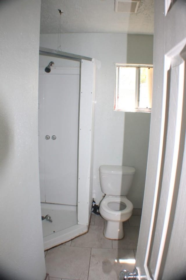 1611 Chapman St, Houston, TX 77009 - full bath with toilet, tile patterned floors, and a textured ceiling