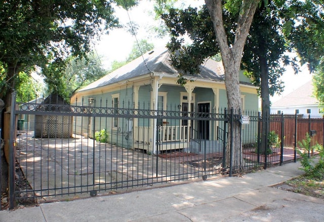 1611 Chapman St, Houston, TX 77009 - shotgun-style home with a fenced front yard, a porch, a shingled roof, and a gate