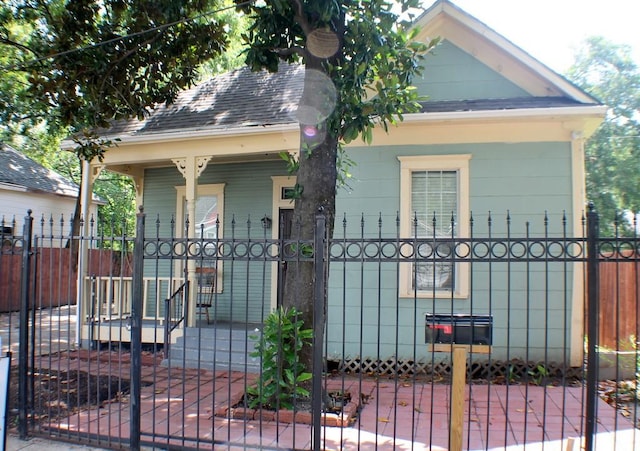 1611 Chapman St, Houston, TX 77009 - view of front of house featuring covered porch, a fenced front yard, a gate, and roof with shingles