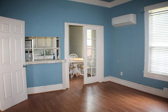 1611 Chapman St, Houston, TX 77009 - empty room featuring an AC wall unit, wood finished floors, and baseboards