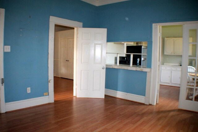 1611 Chapman St, Houston, TX 77009 - kitchen featuring wood finished floors, baseboards, and refrigerator