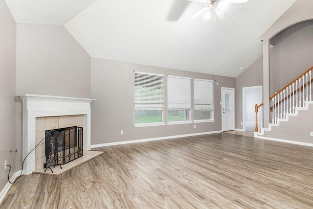 2705 Salt Grass Cir, Deer Park, TX 77536 - unfurnished living room with vaulted ceiling, wood finished floors, a fireplace, a ceiling fan, and stairs