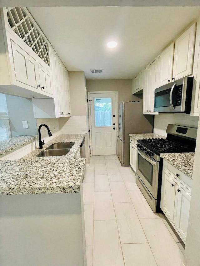 16303 Napa Vine Dr, Houston, TX 77053 - kitchen featuring stainless steel appliances, a sink, and white cabinets